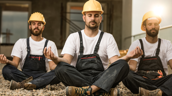 3 construction workers, sitting, practicing meditation.